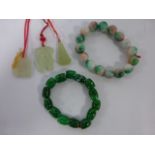 Two Jadeite bead bracelets and three carved Jadeite pendants on red cord chains