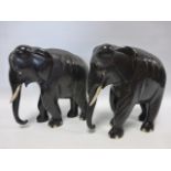 A collection of nine carved elephants, including ebony, the large pair measuring 20.