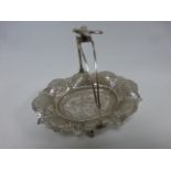 A Middle Eastern silver swing handled dish with bird finial,