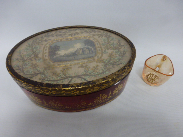 An early 19th Century Regency oval Cranberry glass casket with gilt decoration to the side and with