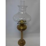 A brass oil lamp with glass chimney and