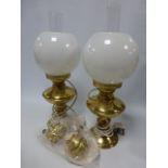 A pair of brass oil lamps with glass chi