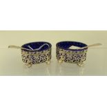 A PAIR OF LATE VICTORIAN PIERCED SILVER SALTS each with blue glass liner, Birmingham 1900,