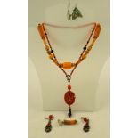 A CARVED CORAL NECKLACE with oval floral pendant on fancy bead "chain", 46cm long, together with a