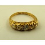 AN EDWARDIAN/EARLY 20TH CENTURY 18CT GOLD FIVE STONE DIAMOND HALF HOOP RING, having four period