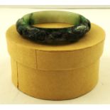 A LATE 19TH CENTURY JADE BANGLE carved with scrolls and symbols, 75mm diameter, 48g