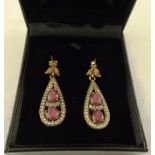 A PAIR OF GOLD FINISHED DROP EARRINGS, set with two ruby coloured stones and simulated diamonds