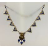 AN EGYPTIAN REVIVAL NECKLET with gold and blue beaded collar suspending a cast metal Pharaoh head