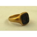 A MID 19TH CENTURY 18CT GOLD SIGNET RING, inset intaglio, crest of a man, the interior of ring