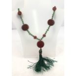 A CINNABAR DISC AND JADE BEAD NECKLACE comprising seven discs, two Buddhas and two carved beads with