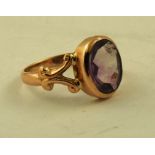 AN EARLY 20TH CENTURY 9CT GOLD LADY'S DRESS RING inset purple coloured stone, possibly an