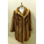 A THREE-QUARTER LENGTH HONEY BROWN MINK COAT having lapel collar and concealed vertical side