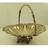 AN ELECTRO-PLATED SWING HANDLED BASKET with repousse floral decoration, raised on cast feet, 30cm