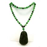 A SPINACH JADE PENDANT carved with a seated Buddha on a necklet, interspersed with emerald jadeite