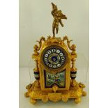 AN ORNATE FRENCH CAST GILT FRAMED MANTEL CLOCK inset with decorative ceramic panels, the dial with