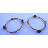 A PAIR OF GILT METAL EGYPTIAN REVIVALIST STYLE BANGLES each with alternating mask and turquoise