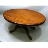 A VICTORIAN MAHOGANY OVAL TILT TOP LOO TABLE, raised on turned pedestal with four carved knee