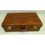 AN EARLY 20TH CENTURY CROCODILE LEATHER SUITCASE, pigskin lined, bears label "The North West Tannery