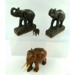 A PAIR OF 20TH CENTURY NATIVE CARVED WOOD ELEPHANTS, each on a loaded metal base, and ANOTHER