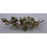 A DIAMOND AND WHITE GOLD COLOURED METAL MOUNTED FLORAL SPRAY BROOCH having stylised flower and