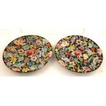 A PAIR OF CHINESE PORCELAIN PLATES hand painted in the famille rose palette on an ebonised ground,