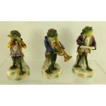 THREE PORCELAIN MEMBERS OF A FROG BAND, includes Conductor, Flautist and Trumpet Player, painted and