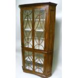 A 19TH CENTURY WALNUT STANDING CORNER CUPBOARD of Georgian design, having canted front, the upper