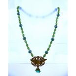 A 1930's NECKLACE with green mosaic beads and eagle pendant, 60cm long