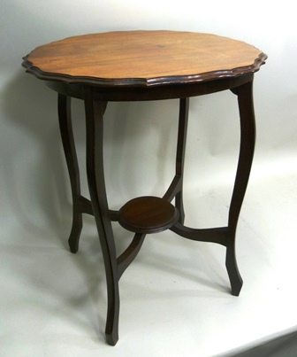 AN EDWARDIAN MAHOGANY OCCASIONAL TABLE having pie-crust rim, on four shaped supports united by