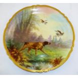 A LIMOGES HAND PAINTED CHARGER, depicting a Pointer and game birds in a woodland, green factory back