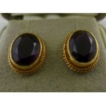 A PAIR OF GOLD COLOURED METAL STUD EARRINGS each set with amethyst in wire surround
