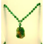 A JADE SAUTOIR with honey and emerald jade pendant carved with two fish, on plain beads, 92cm long
