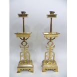 A PAIR OF CHINESE BRASS CANDLESTICKS having rectangular drip pans, pierced character stems, on