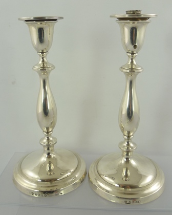 ELLIS & CO A PAIR OF GEORGE V SILVER CANDLESTICKS of classical form with baluster stems on