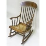 A LATE 19TH CENTURY STAINED BEECH FRAMED ROCKING CHAIR having bobbin turned spindle decoration to