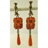 A PAIR OF EARLY 20TH CENTURY SIMULATED CORAL ART DECO EARRINGS of carved coral design with screw