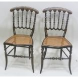 A PAIR OF LATE VICTORIAN SALON CHAIRS, having ebonised frames with painted decoration, spindle backs