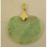 A CARVED DECORATED JADEITE PENDANT with engraved Chinese writing, mounted on a gold coloured metal