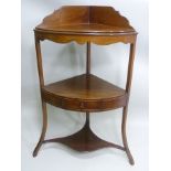 A 19TH CENTURY MAHOGANY CORNER WASHSTAND, gallery back, middle tier fitted drawer raised on outswept