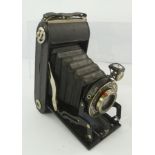 A MID 20TH CENTURY WIRGIN 120 ROLL FILM CAMERA, in a black vinyl case, having a dark brown leather