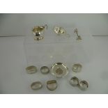 A COLLECTION OF SILVER ITEMS to include; seven various napkin rings, a condiment, tea strainer,