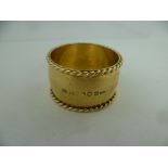 GUILD OF HANDICRAFT - DEREK ELLIOT A SILVER GILT AND SPOT HAMMERED NAPKIN RING with rope twist