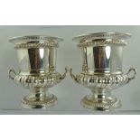 A PAIR OF SILVER PLATED CAMPANA URN FORM WINE COOLERS, fitted two handles, on circular gadrooned