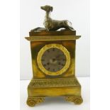 AN EARLY 19TH CENTURY BRASS AND WHITE METAL FRENCH MANTEL CLOCK having greyhound pediment, Roman