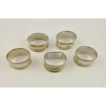 EDWARD VINER & SONS A SET OF FOUR OVAL SILVER NAPKIN RINGS having engine turned banding, un-