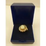 A GOLD COLOURED METAL AND OPAL MOUNTED CLUSTER RING having 15 stone head and split wire shank,
