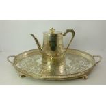 AN OVAL SILVER PLATED GALLERIED TRAY, having chased fern decoration, with two handles, raised on bun
