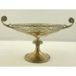 A SILVER COMPORT having garland fretted bowl, twin lion mask scroll handles, on guilloche rimmed