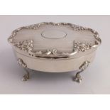 AN EDWARDIAN SILVER TRINKET OR JEWELLERY BOX of oval form with embossed floral and engine turned