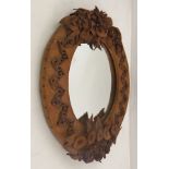 A LEATHER FRAMED OVAL WALL MIRROR, with applied leather floral decoration, overall 50cm x 40cm